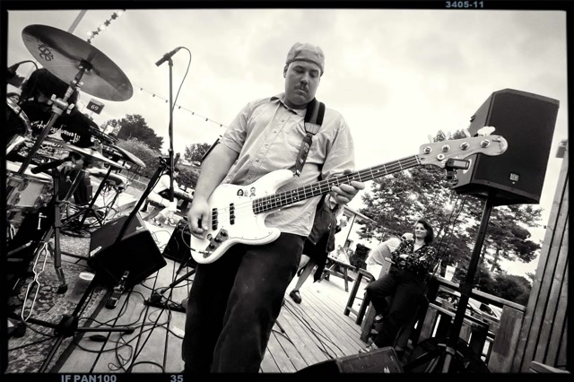 Kazadur en concert en plein air, bassiste au premier plan